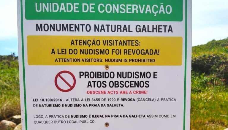 Placa de sinalização alerta sobre prática de nudismo na Praia da Galheta