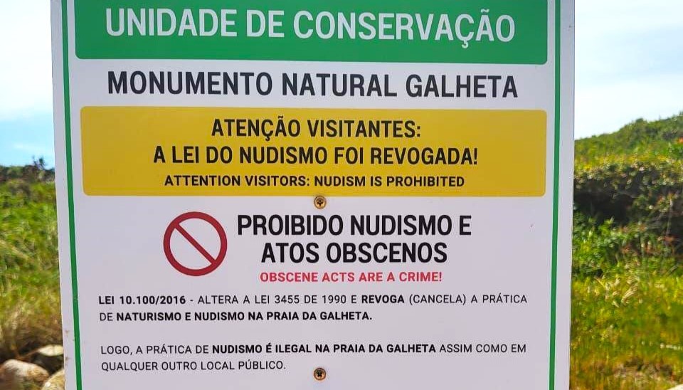 Placa de sinalização alerta sobre prática de nudismo na Praia da Galheta